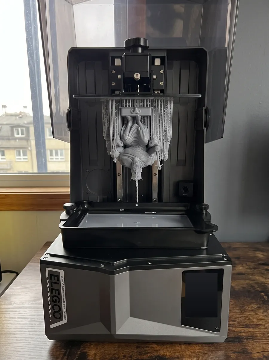 The Emperor statue hanging from the build plate of the resin printer