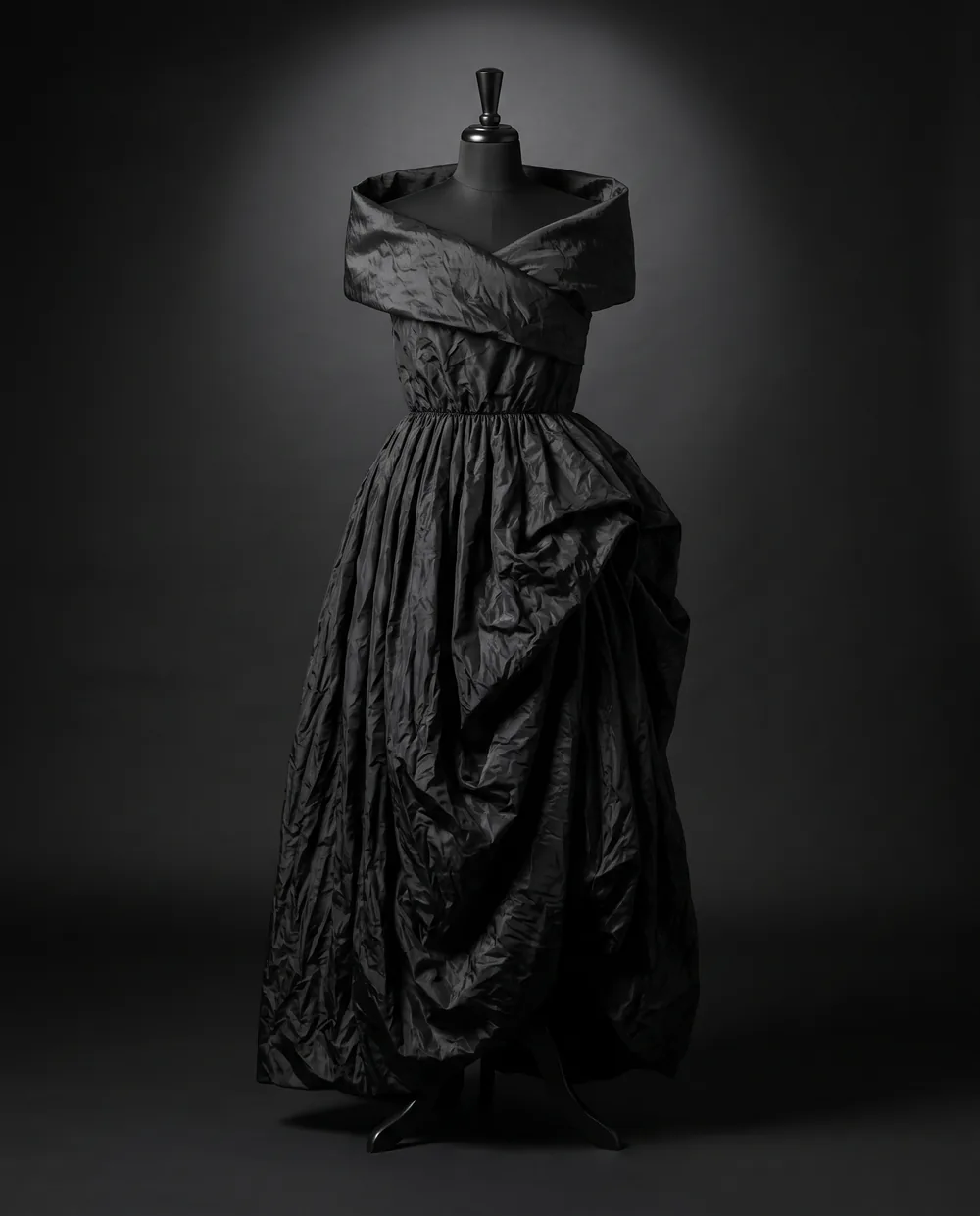 The Collar Dress on a black dress form: a black taffeta dress with a wide folded collar and a gathered skirt