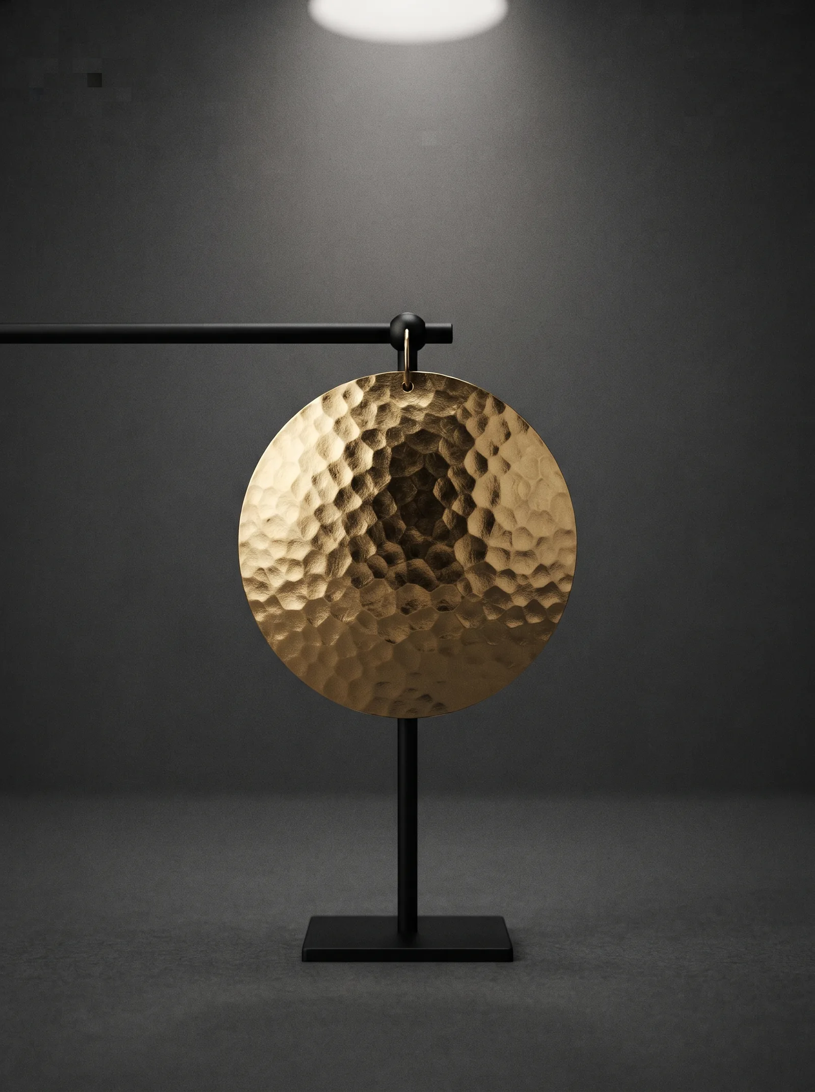 The Ear Disc hanging from a black stand: a single round earring of hammered gold